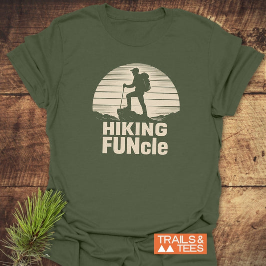 Hiking FUNcle T-Shirt featuring a hiker graphic on olive-green fabric, highlighting comfort and durability with ring-spun cotton and DTF prints, beside TRAILS & TEES logo.