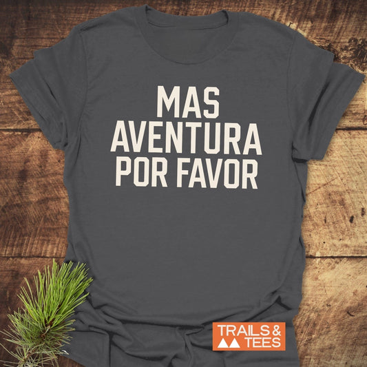 Mas Aventura T-Shirt in charcoal-gray with bold off-white text, styled with a pine sprig and TRAILS & TEES logo, embodying outdoor adventure.