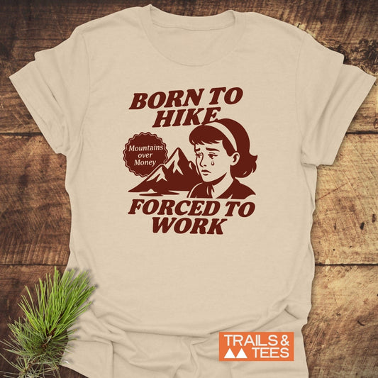 Born To Hike T-Shirt featuring a cartoon girl and mountain graphic, slogan Mountains over Money, crafted from soft cotton for comfort and durability, by Trails & Tees.