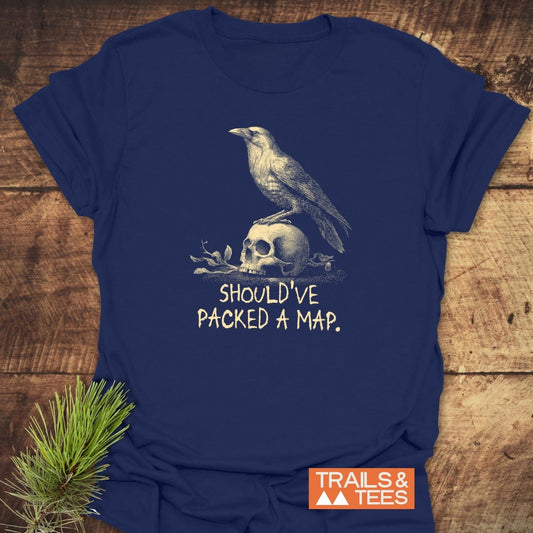 No Wi-Fi Funny T-Shirt featuring a crow on a skull illustration, slogan SHOULD’VE PACKED A MAP, with TRAILS & TEES logo, laid on a wooden surface.