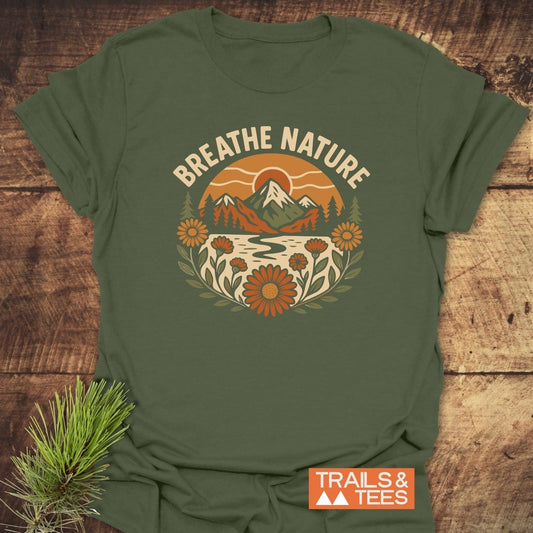 Breathe Nature T-Shirt featuring a retro nature graphic with mountains and wildflowers. Made from soft cotton, it's perfect for outdoor enthusiasts.