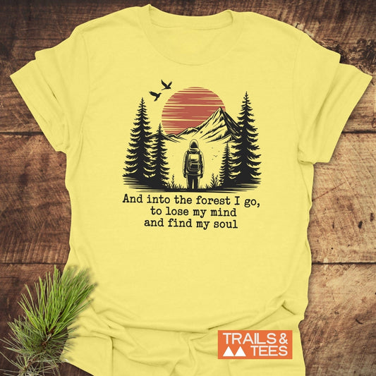 And Into The Forest I Go T-Shirt with a hiker graphic among evergreens and mountains, crafted from soft ring-spun cotton by TRAILS & TEES.