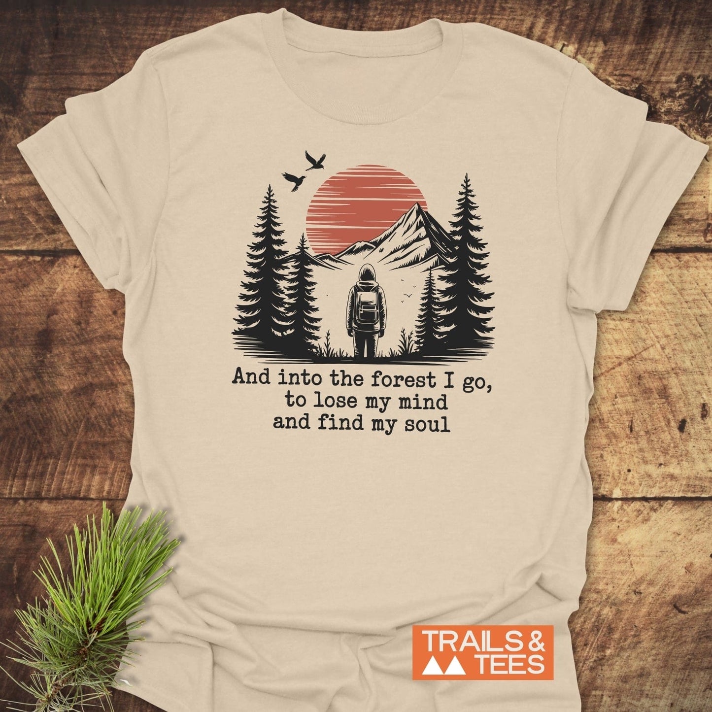 And Into The Forest I Go T-Shirt featuring a nature scene with mountains, trees, and hiker, crafted from soft cotton for comfort, durability, and eco-friendly production.
