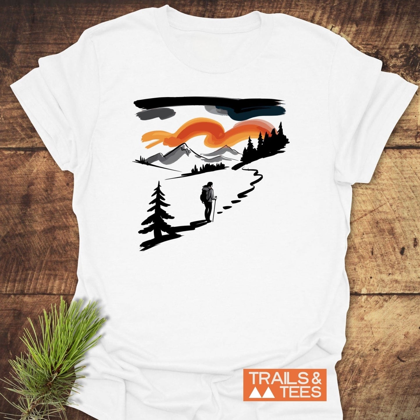 Minimalist Ink Hiking T-Shirt featuring a brush-stroke hiker design with mountains and sunset, on soft ring-spun cotton, emphasizing outdoor adventure and comfort.