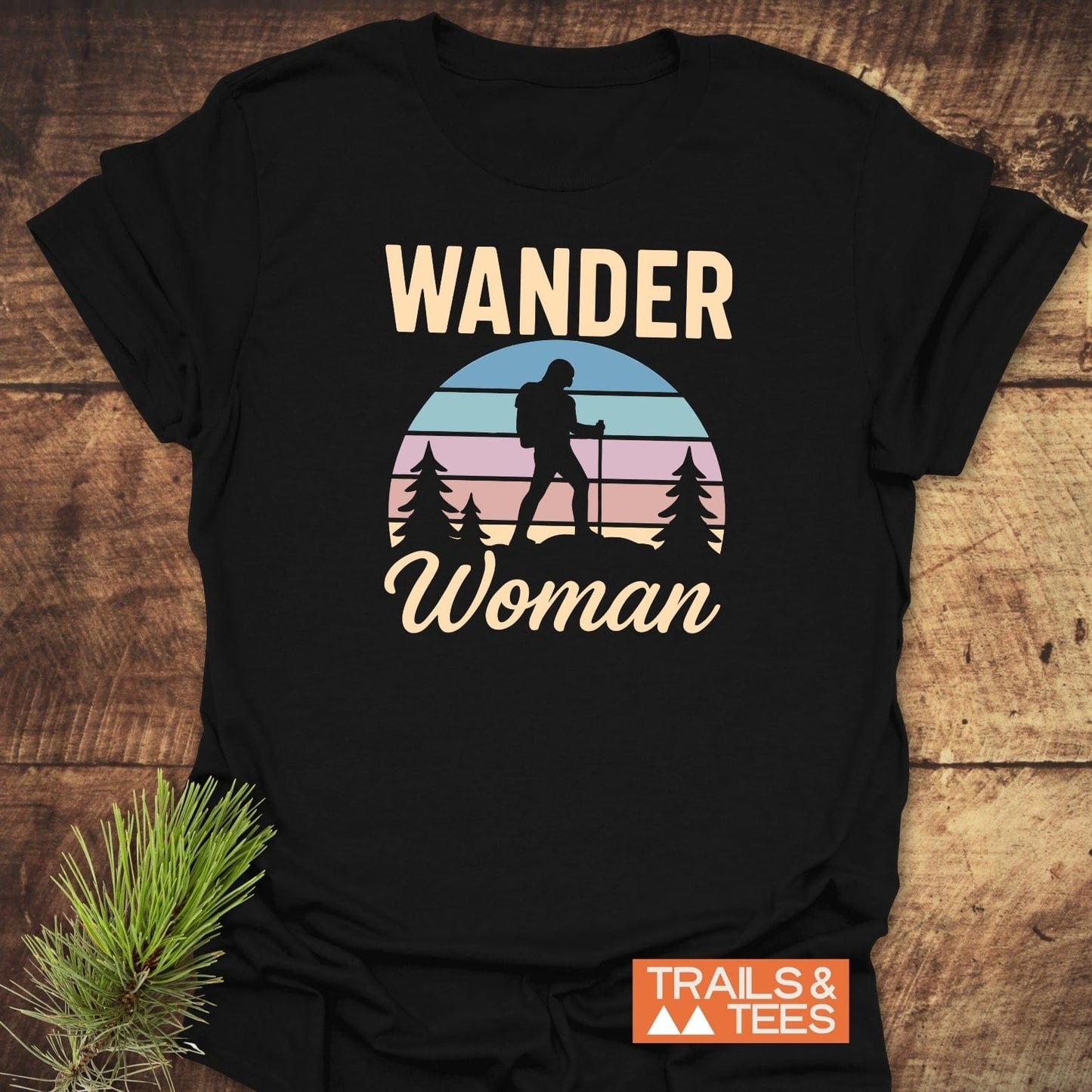 Wander Woman Retro T-Shirt featuring a silhouetted backpacker and pastel sunset graphic, crafted from soft, lightweight cotton for everyday adventure and comfort.