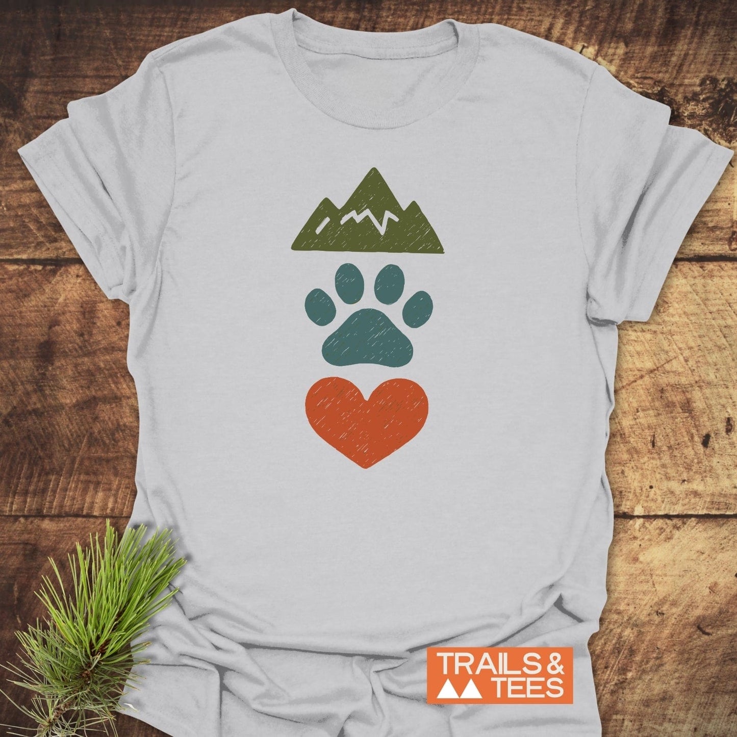 Mountains & Dogs Love T-Shirt: light-gray crew-neck with green mountain, teal paw print, orange heart design; soft ring-spun cotton, durable print, eco-friendly production.