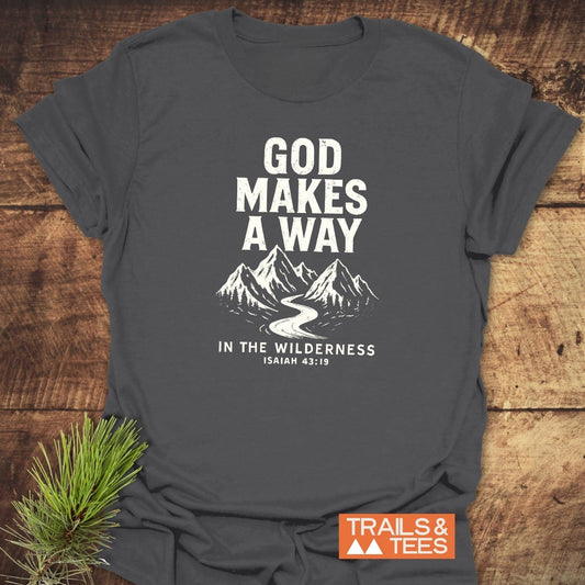 Charcoal-gray God Makes A Way T-shirt with mountain graphic and Isaiah 43:19 reference, laid flat, highlighting outdoor adventure theme and durable design.