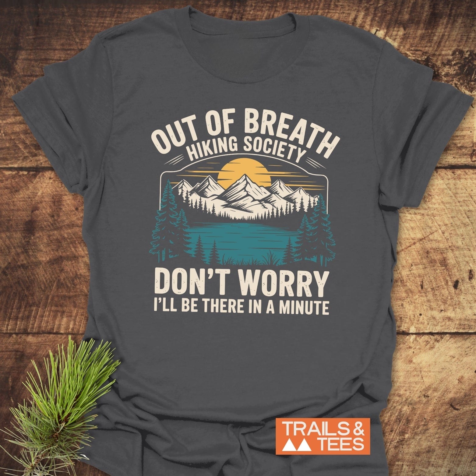 Out Of Breath Funny T-Shirt featuring a mountain-lake-forest scene and humorous text, crafted from soft cotton for comfort, with durable prints and a small TRAILS & TEES logo.