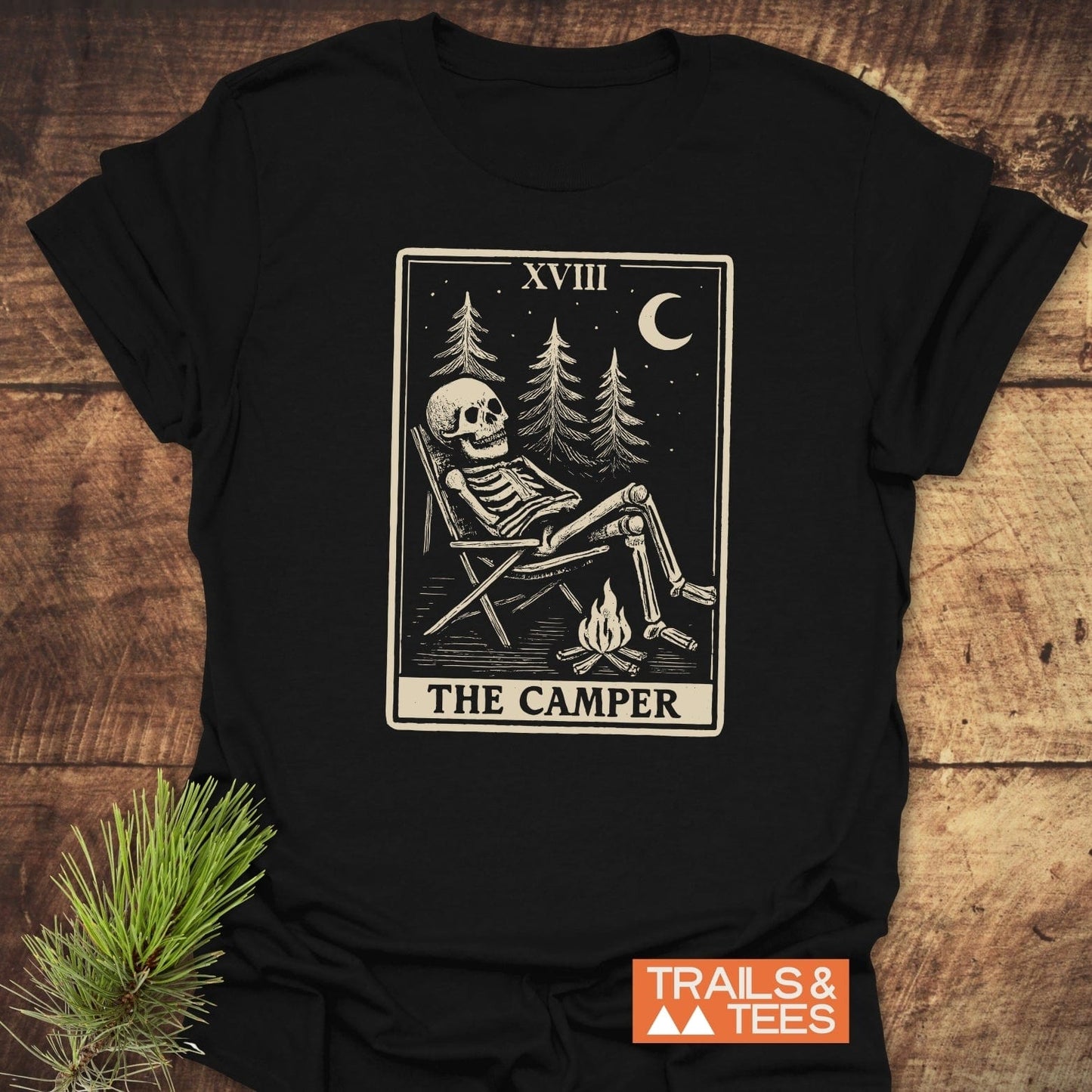 The Camper Tarot T-Shirt: vintage tarot illustration of a skeleton camping, crafted from soft cotton for lasting comfort and outdoor style.