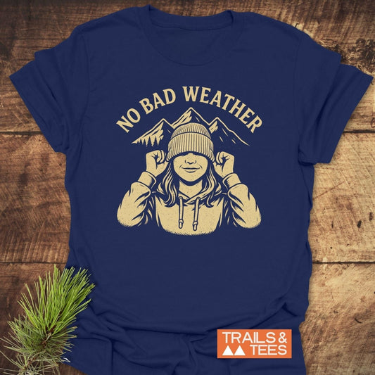 No Bad Weather T-Shirt featuring a hoodie-clad figure with mountain peaks, crafted from soft cotton, durable print, emphasizing outdoor adventure and comfort.
