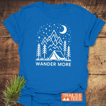 Wander More T-Shirt features a camping scene with pine trees, mountains, and a starry sky, highlighting adventure-ready, soft cotton comfort.