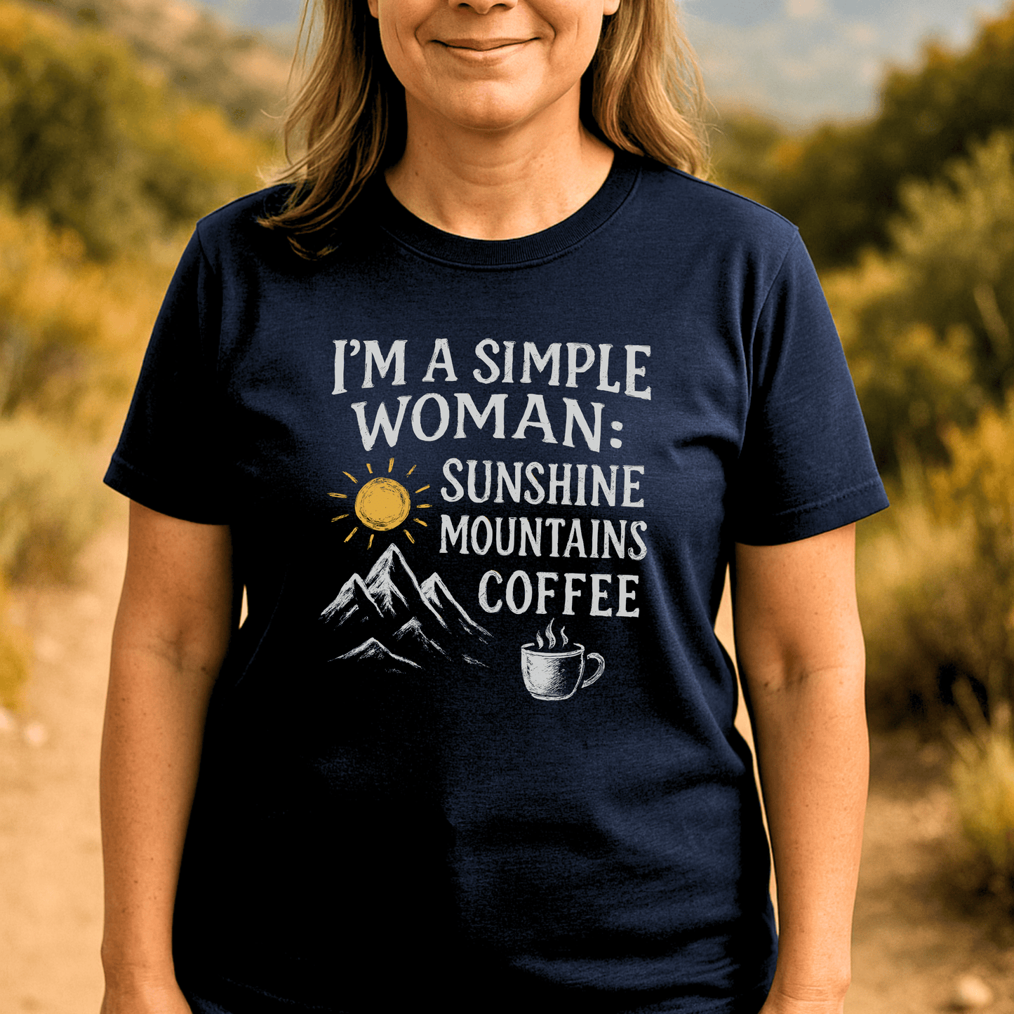 Person wearing the Simple Woman Sunshine T-Shirt, featuring “SUNSHINE MOUNTAINS COFFEE” text with sun, mountain, and coffee mug graphics, emphasizing outdoor adventure spirit.