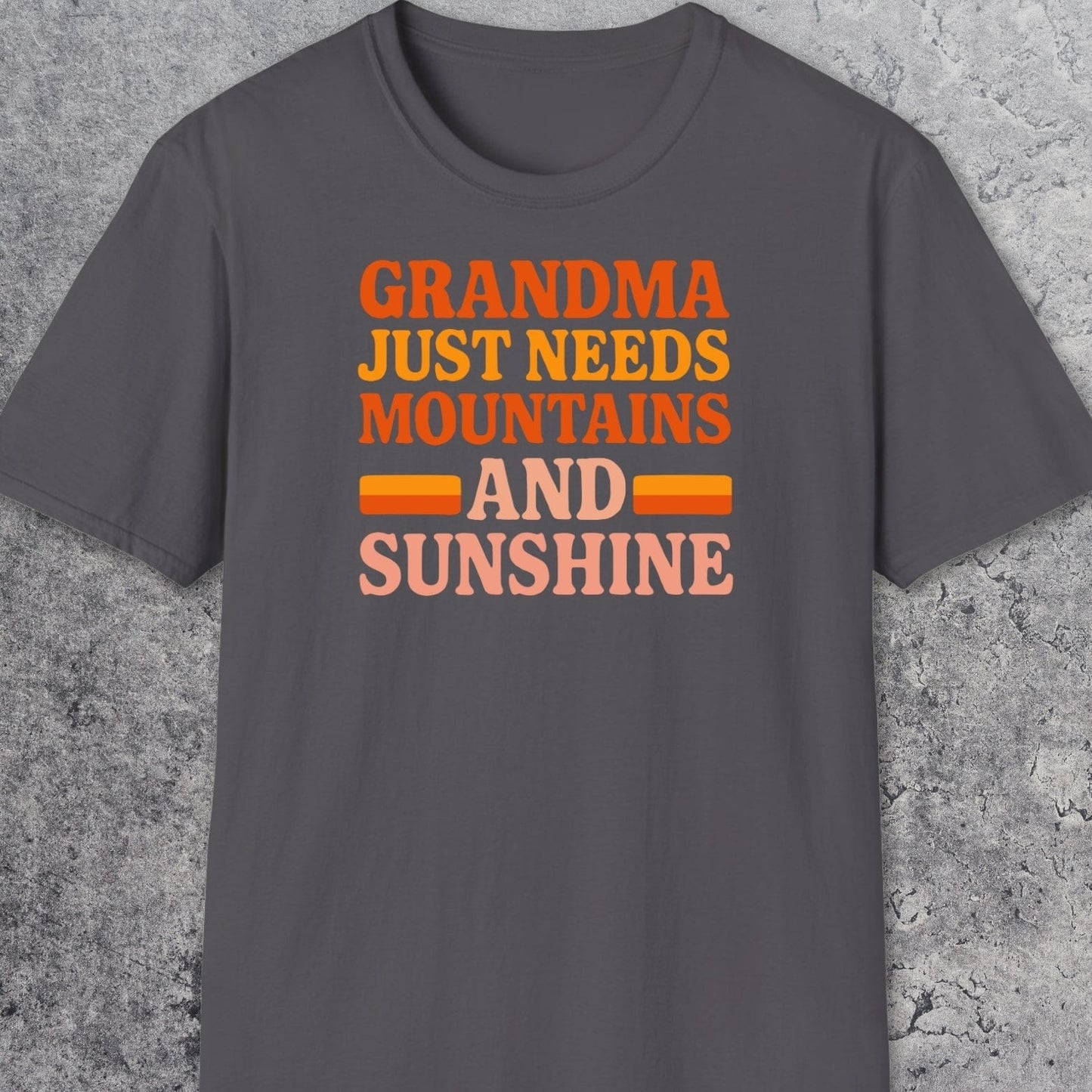 Retro 80s Grandma Mountains T-Shirt laid flat, features warm-toned text celebrating nature. Made from soft, ring-spun cotton for comfort and durability.