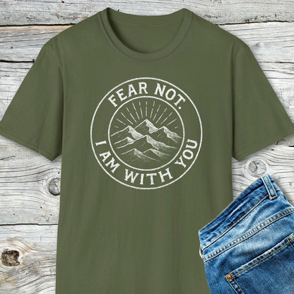 Fear Not Mountain T-Shirt with white mountain graphic and motivational text, paired with blue denim jeans on a wooden background, showcasing outdoor-inspired style and comfort.