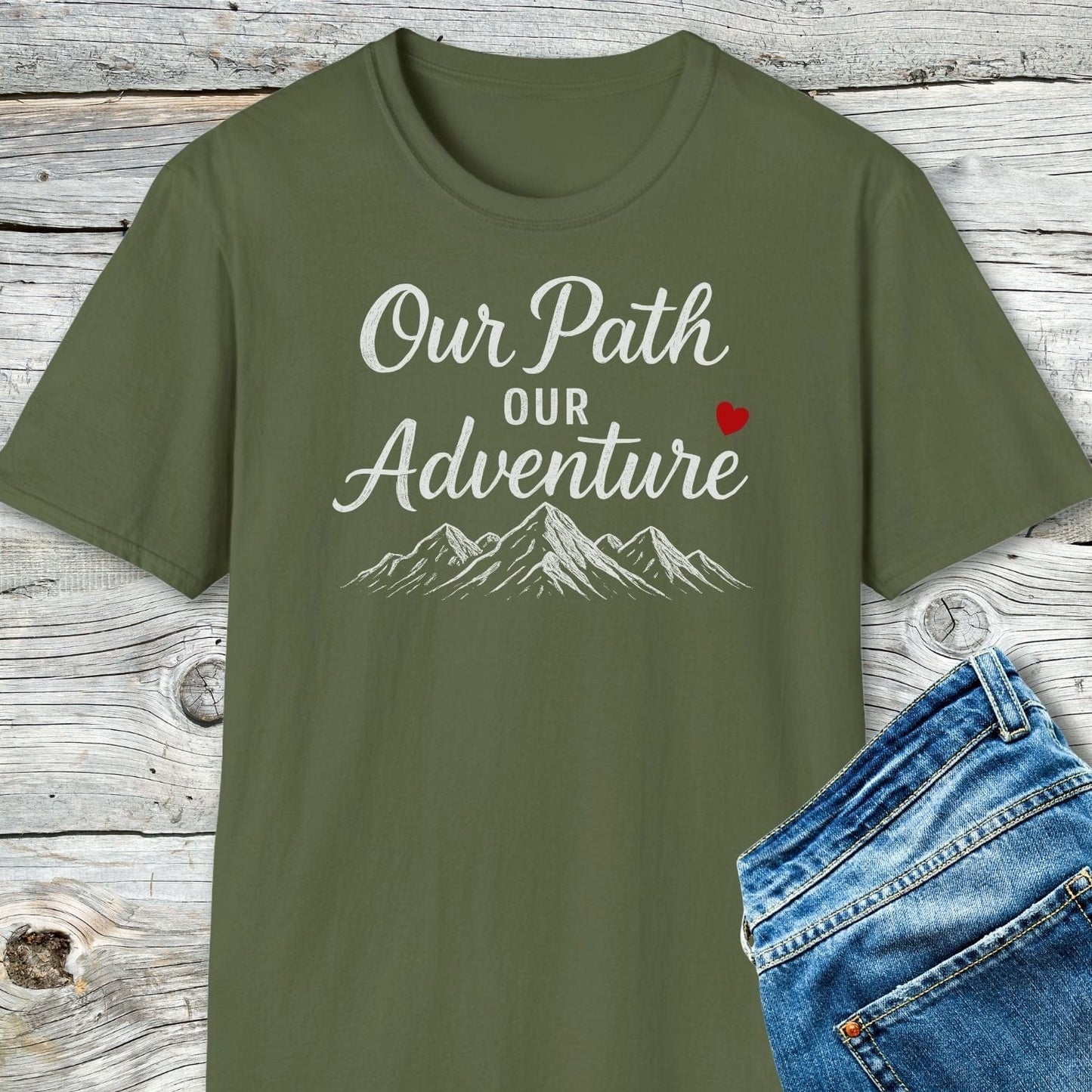Olive-green Our Path Couple T-Shirt with mountain sketch and heart, displayed with blue jeans; crafted from soft cotton for outdoor comfort and durability.