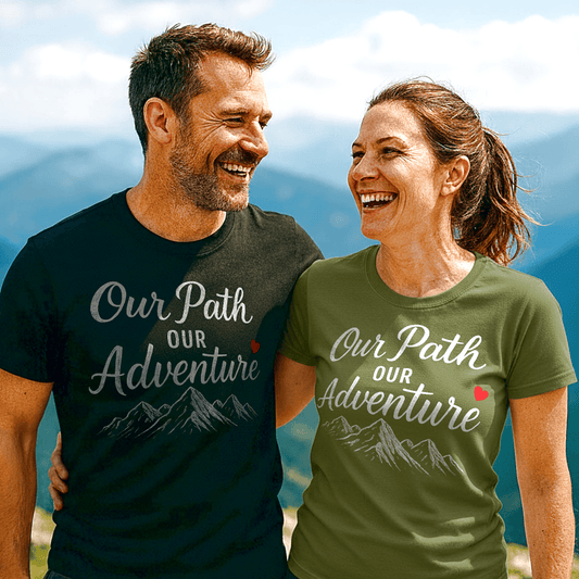 Couple wearing Our Path Our Adventure t-shirts with mountain graphic, standing arm-in-arm on a mountain overlook, showcasing trail-tested comfort and durable design.