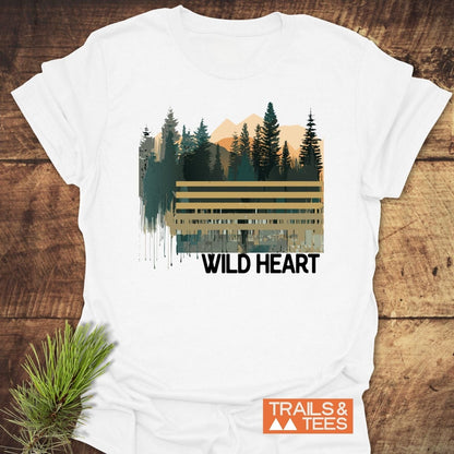 Wild Heart Graphic T-Shirt featuring a pine and mountain scene with “WILD HEART” slogan, crafted from soft cotton, ideal for outdoor enthusiasts.