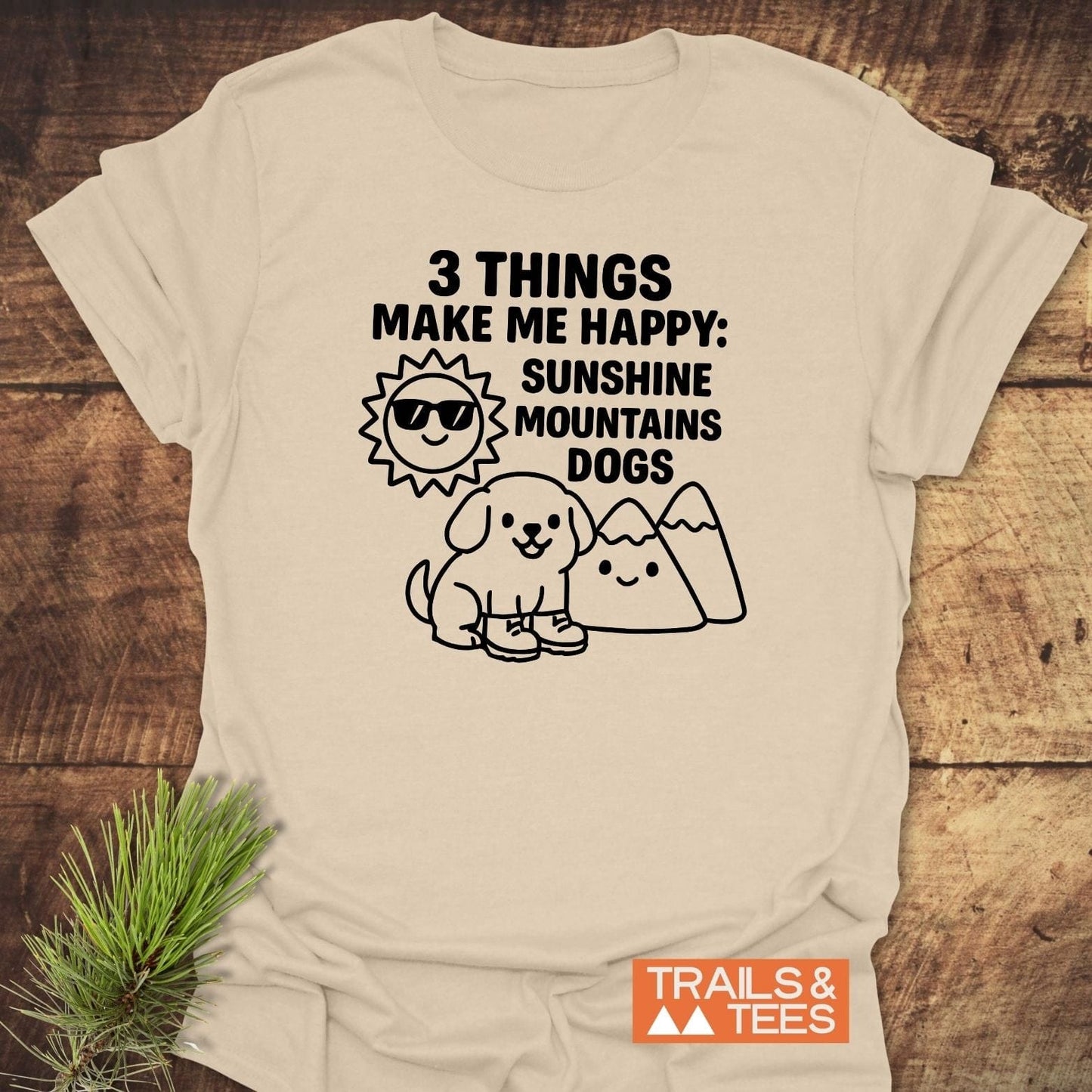 Sunshine Mountains Dogs T-Shirt featuring playful cartoons of a sun, dog, and mountains. Made from soft cotton, ideal for outdoor enthusiasts.
