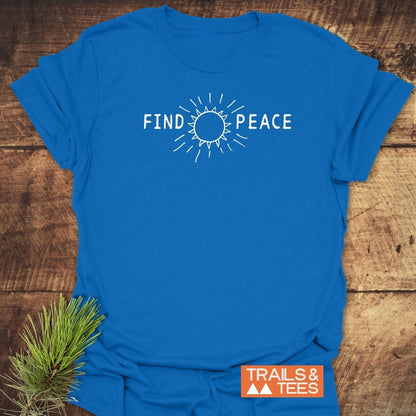 Find Peace T-Shirt featuring a white stylized sun graphic, laid flat with a pine sprig accent, emphasizing comfort and durability for outdoor enthusiasts.