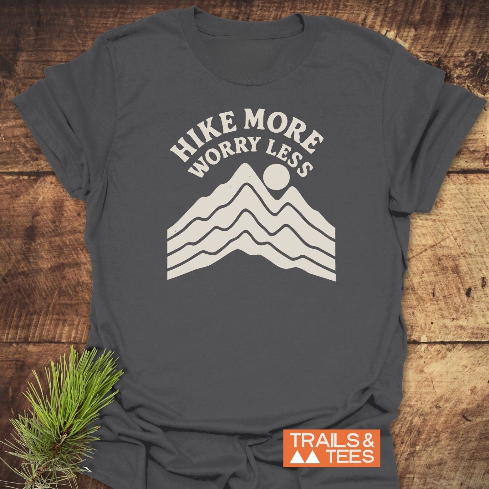 Dark-gray Hike More Worry Less T-shirt with mountain graphic, laid flat. Made from soft ring-spun cotton, features durable print, designed for outdoor enthusiasts.