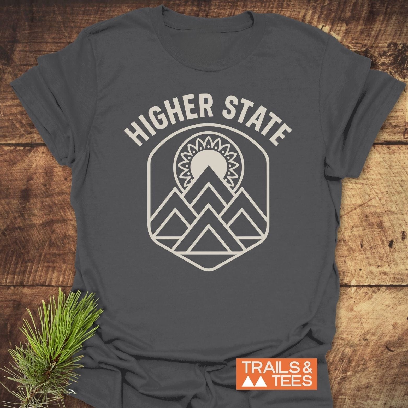 Higher State Mountain Mandala T-Shirt with a mountain and sun emblem on a charcoal-gray tee, perfect for outdoor enthusiasts and everyday comfort.