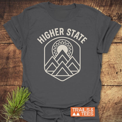 Higher State Mountain Mandala T-Shirt with a mountain and sun emblem on a charcoal-gray tee, perfect for outdoor enthusiasts and everyday comfort.