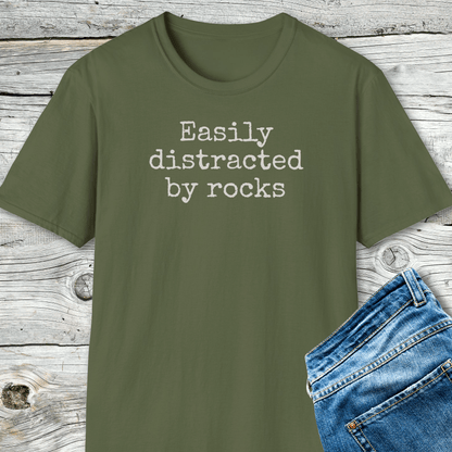 Easily Distracted By Rocks T-Shirt paired with blue jeans, showcasing a soft, durable tee designed for outdoor enthusiasts, emphasizing comfort and sustainability.