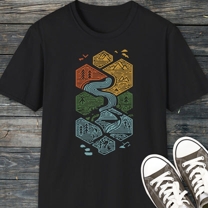 Everything Flows T-Shirt featuring interlocking hexagons with landscape motifs, laid on wood, paired with black-canvas sneakers. Lightweight, ring-spun cotton for everyday adventure.