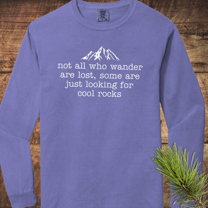 Looking For Cool Rocks Comfort Colors Long-Sleeve Tee with mountain print, laid on wood, features 100% ring-spun cotton for softness and relaxed fit.