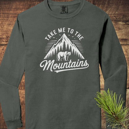 Copy of Mountain Energy Comfort Colors Long-Sleeve Tee featuring a mountain and bear design, laid flat with a pine branch beside it.