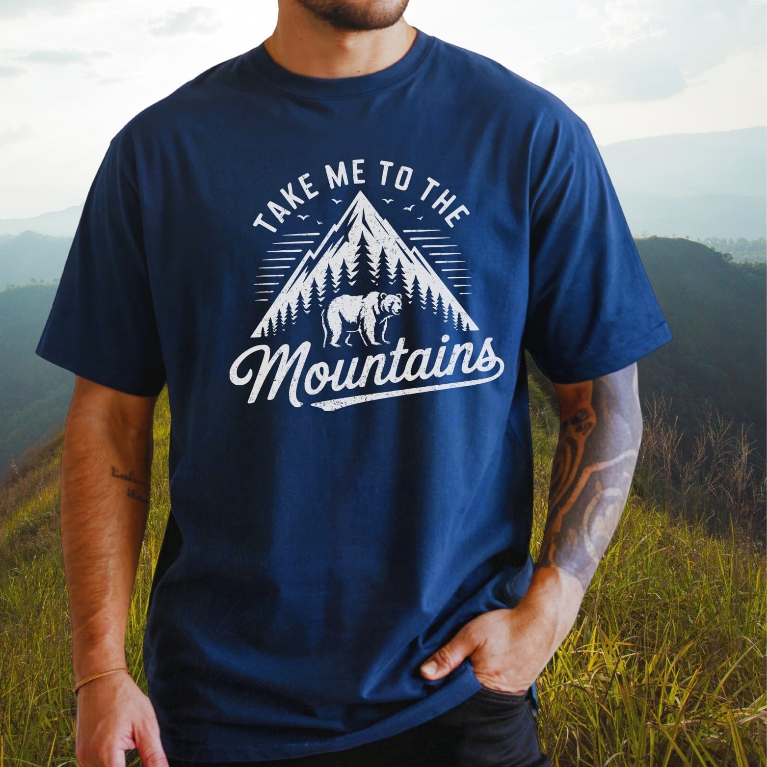 Person wearing Take Me To The Mountains Comfort Colors 1717 Tee, featuring a mountain scene with a bear and birds, showcasing its relaxed fit and durable design.