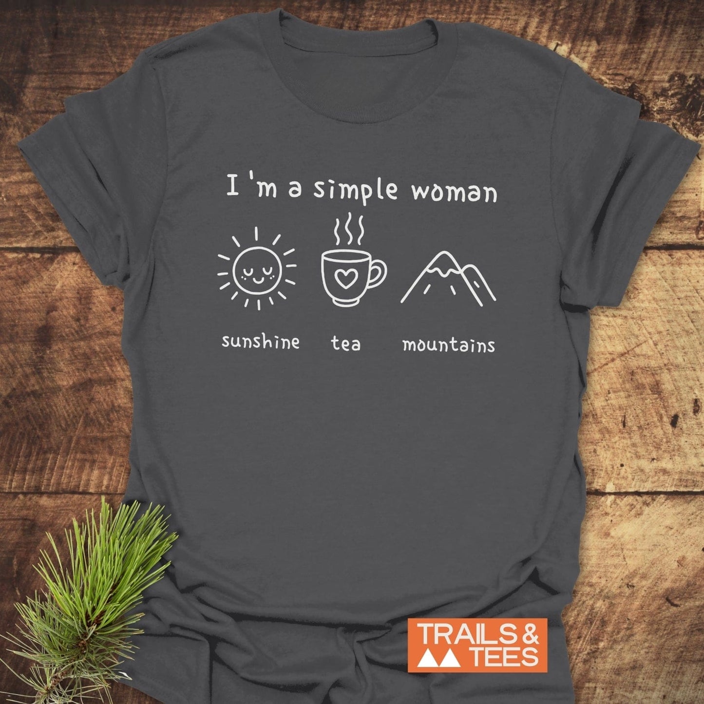 I'm A Simple Woman - Sunshine Tea Mountains T-Shirt featuring white line icons and text, with a small pine sprig and Trails & Tees logo.
