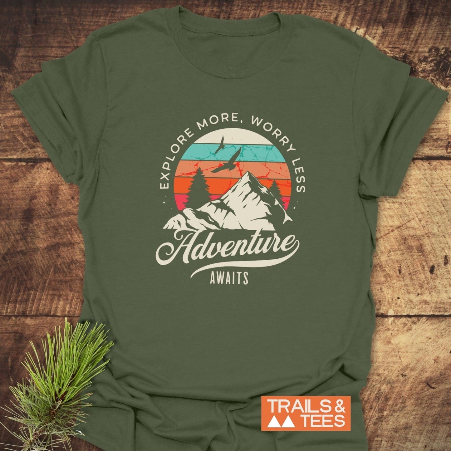 Adventure Awaits Retro T-Shirt featuring a sunset graphic with mountains and pine trees, crafted from soft cotton for comfort and durability, ideal for outdoor enthusiasts.