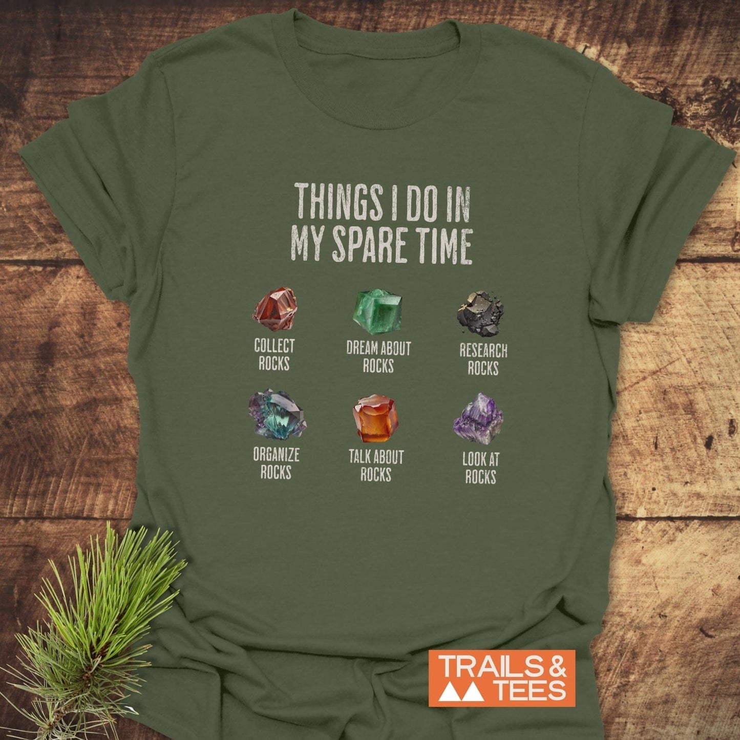Sparetime Rock Lover T-Shirt with six rock-themed activities and illustrations on the chest, featuring a TRAILS & TEES logo in the corner.
