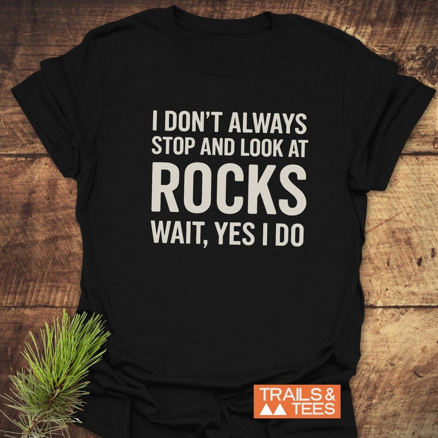Black T-shirt with I DON’T ALWAYS STOP AND LOOK AT ROCKS WAIT, YES I DO in white text, featuring a Trails & Tees logo, titled I Don't Always... Rock Lover T-Shirt.