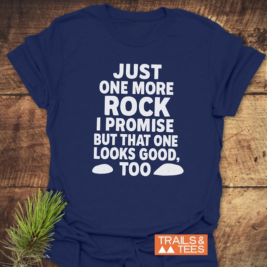 Navy-blue Just One More Rock Funny T-Shirt with bold white slogan and rock graphics, staged with pine sprig and TRAILS & TEES logo.