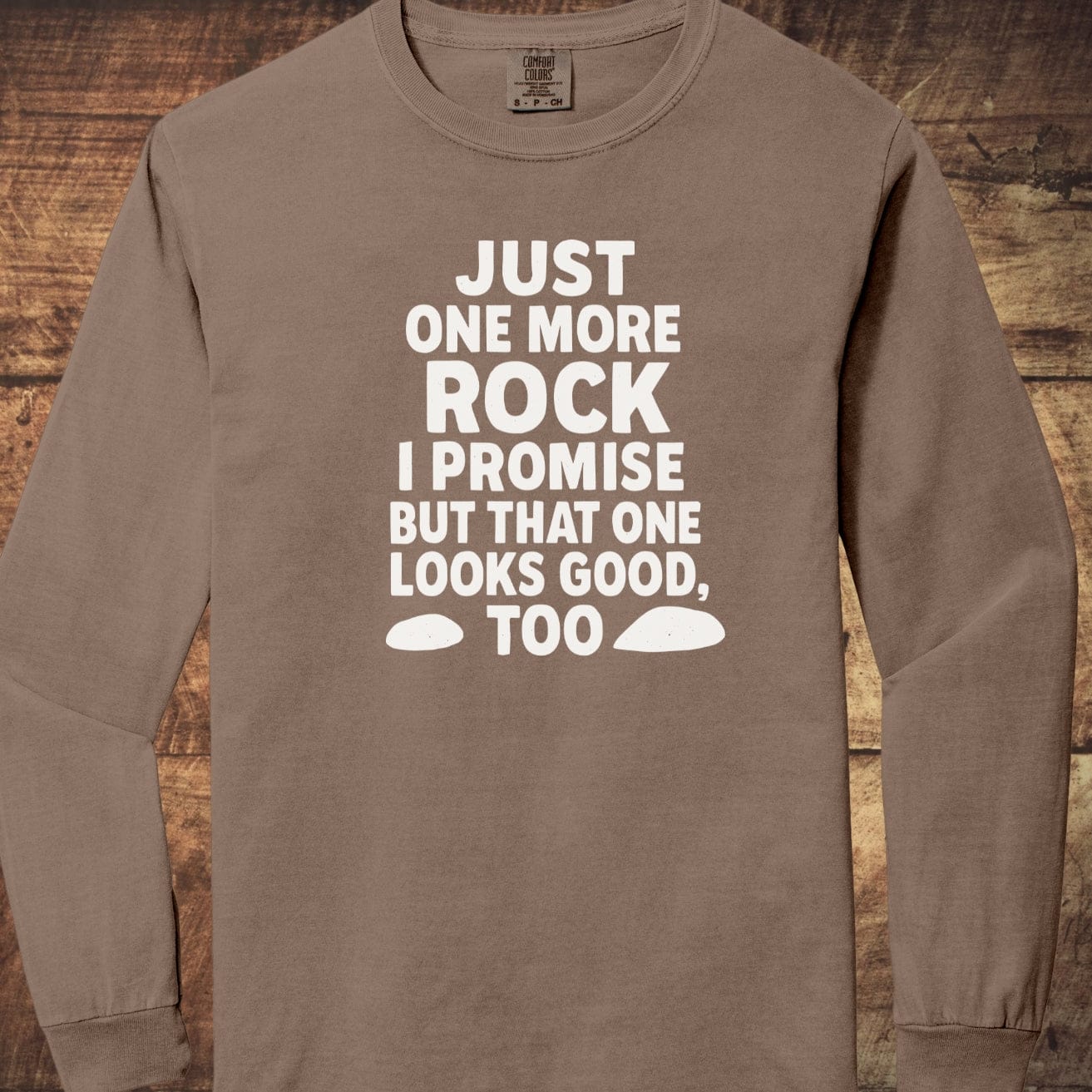 Just One More Rock Comfort Colors Long-Sleeve Tee in brown, featuring bold white text and rock silhouettes, made of 100% ring-spun cotton, laid flat.