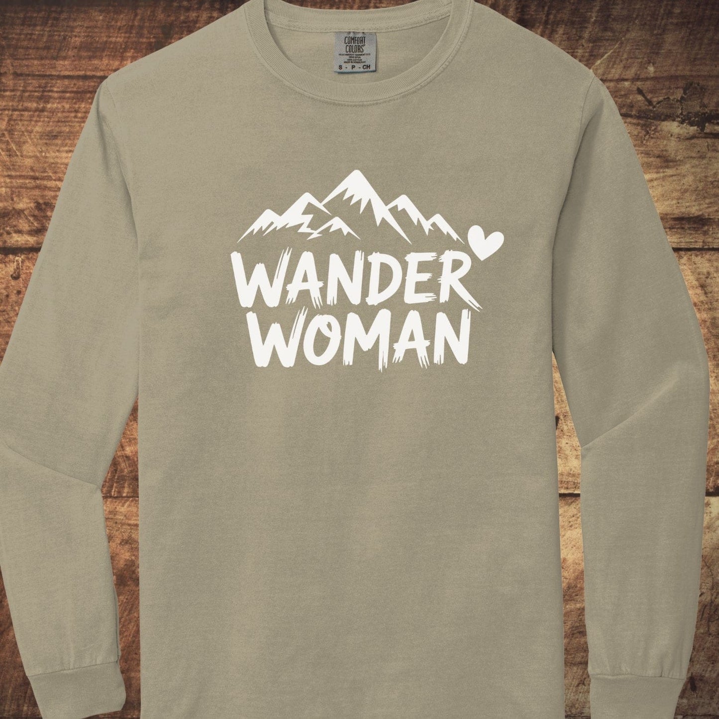 Wander Woman Comfort Colors Long-Sleeve Tee with mountain graphic and WANDER WOMAN text, showcasing softness and relaxed fit from 100% ring-spun cotton.