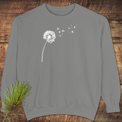 Dandelion Comfort Colors Sweatshirt on wooden surface, featuring a white dandelion print. Made of 80% cotton, 20% polyester, relaxed fit.
