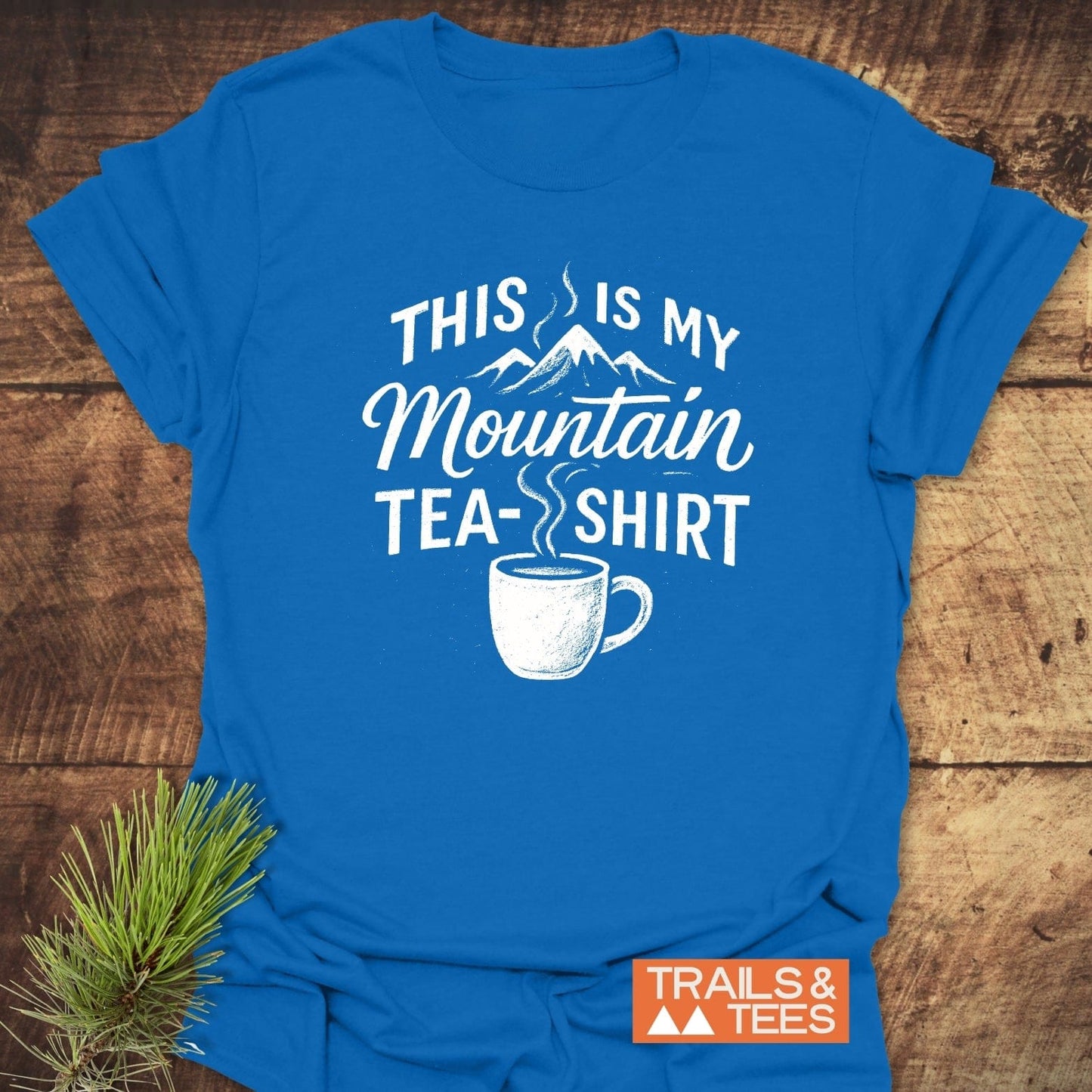 Mountain Tea T-Shirt featuring a mountain graphic and teacup print on blue fabric; crafted from soft cotton for comfort and pre-shrunk for a reliable fit.