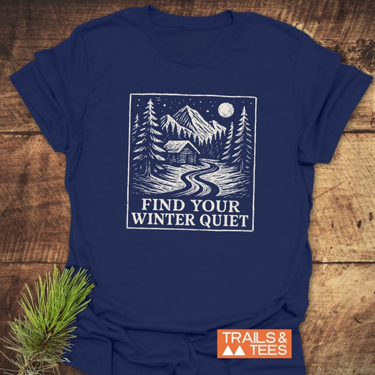Find Your Winter Quiet Cabin T-Shirt featuring a white mountain cabin illustration on navy-blue, crafted from soft ring-spun cotton, promoting outdoor adventures and sustainability.