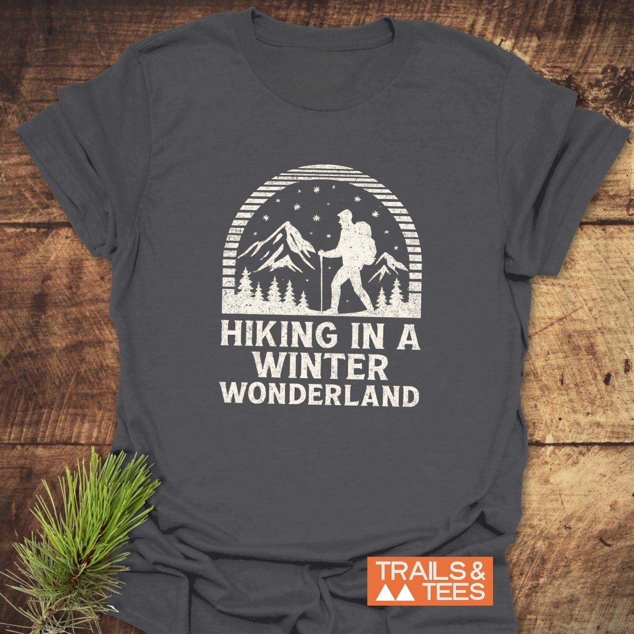 Hiking In A Winter Wonderland T-Shirt features a vintage winter scene with a hiker, crafted from soft cotton for comfort and durability.