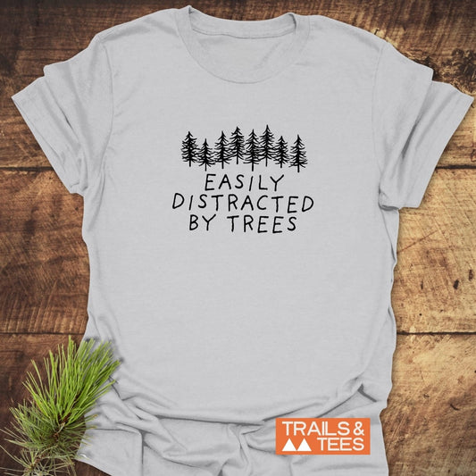 Easily Distracted By Trees T-Shirt with evergreen tree graphic; soft, lightweight ring-spun cotton, pre-shrunk, durable prints. Suitable for outdoor enthusiasts.