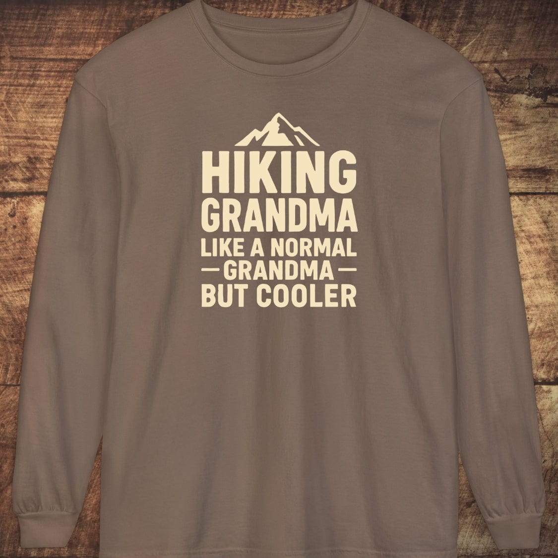 Hiking Grandma Comfort Colors Long-Sleeve Tee featuring a mountain graphic and bold text, laid flat, showcasing its soft, relaxed fit and classic style.