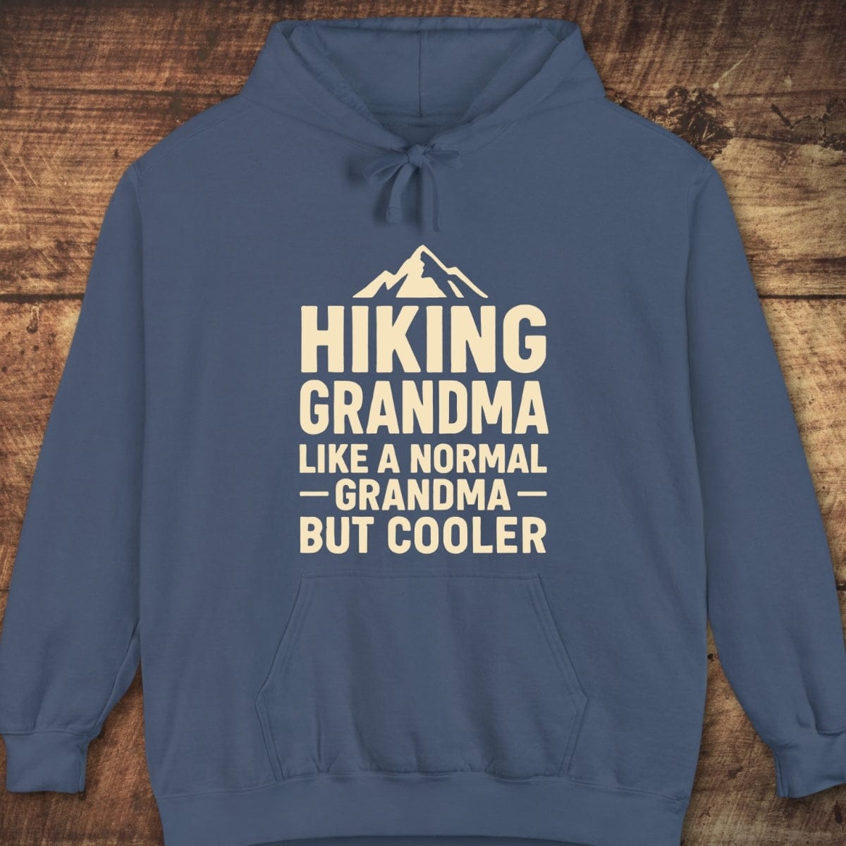 Blue pullover hoodie with Hiking Grandma and mountain graphic, featuring a relaxed unisex fit, jersey-lined hood, and front pouch pocket, ideal for outdoor comfort.