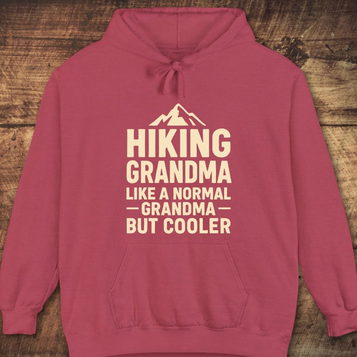 Hiking Grandma Comfort Colors Hoodie with a mountain graphic and text, laid flat; soft, garment-dyed fleece, relaxed fit, ideal for layering.