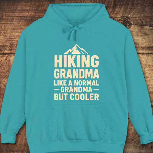 Hiking Grandma Comfort Colors Hoodie with mountain graphic and text. Features drawstring hood, kangaroo pocket, ribbed cuffs, garment-dyed for a vintage feel.