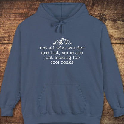Looking For Cool Rocks Comfort Colors Hoodie with mountain graphic and quote, laid flat. Features relaxed fit, jersey-lined hood, and front pouch pocket.