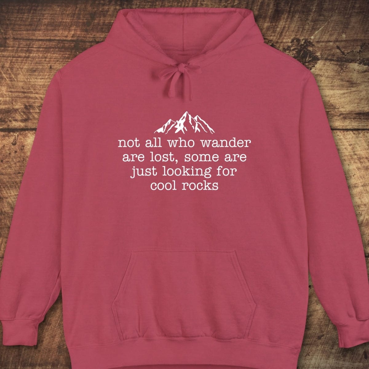 Looking For Cool Rocks Comfort Colors Hoodie featuring a mountain peak design and slogan, laid flat, showcasing its cozy, garment-dyed fabric and relaxed unisex fit.