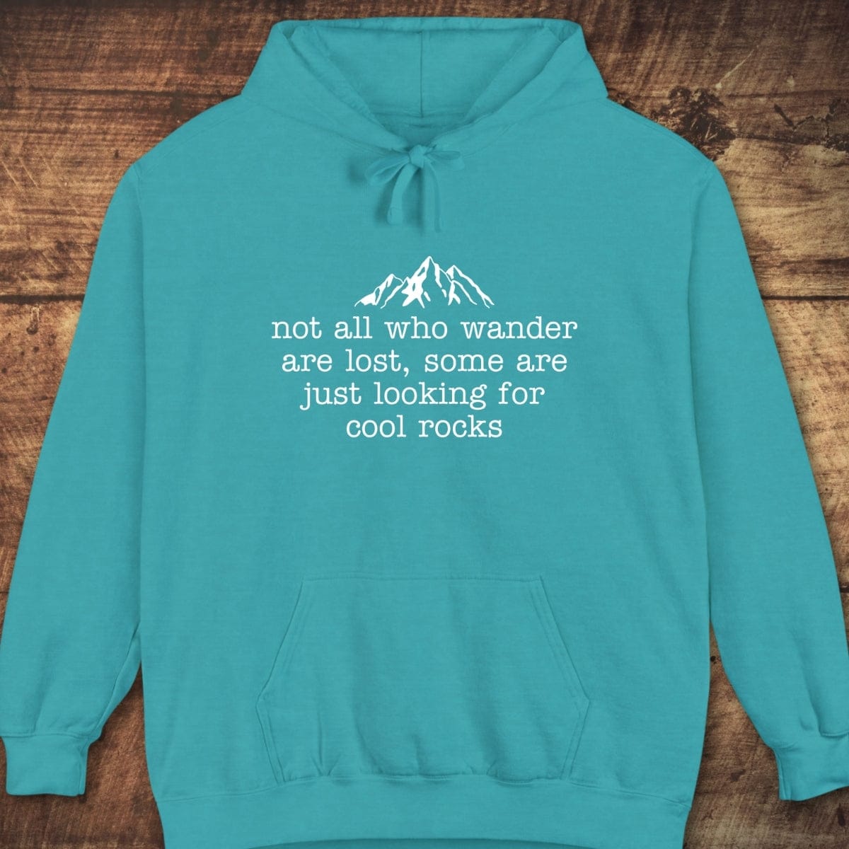 Looking For Cool Rocks Comfort Colors Hoodie features a mountain design and text on the chest, showcasing a relaxed fit with a front pouch pocket.